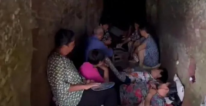 为解暑,村民在墓穴躺坐一排乘凉!为何官方不建议游客前往?